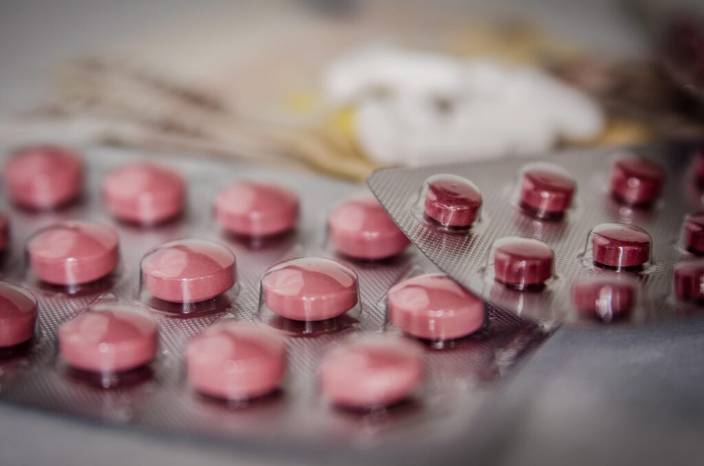 Close-up of red pills in blister packaging, arranged in overlapping packs.