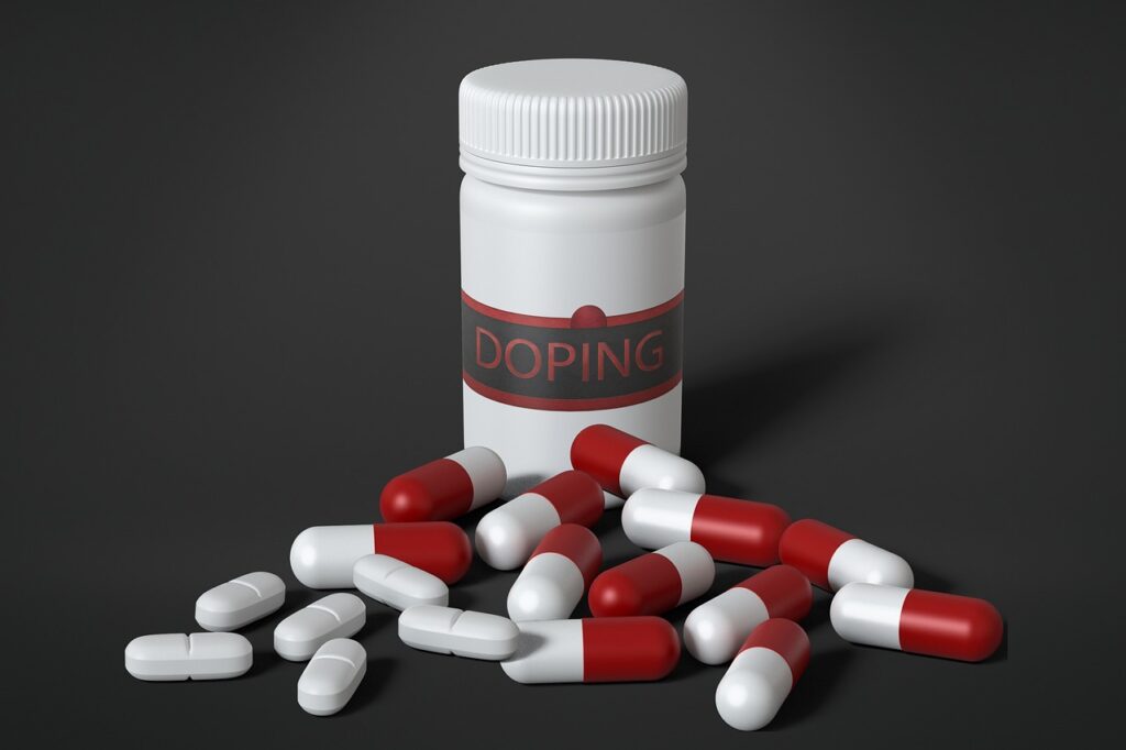 White bottle labeled "DOPING" with scattered red and white capsules and white tablets on a dark background.
