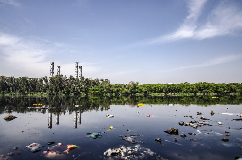 contaminated river with indutrial complex in distance illustrating the importance of water pollutants testing