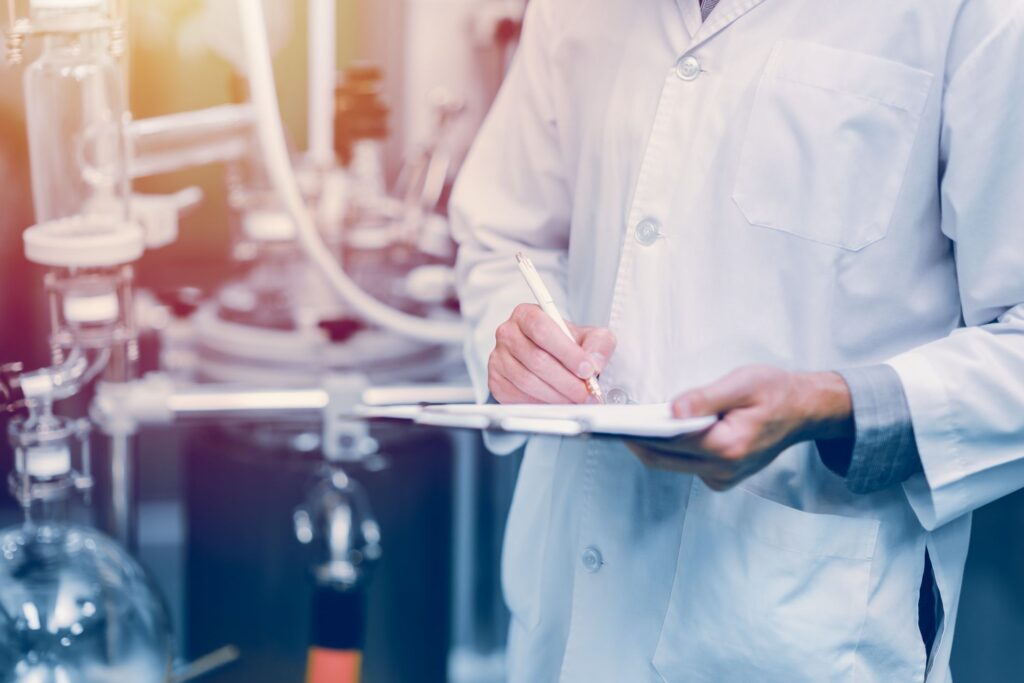 Image of worker in labcoat with clipboard illustrating SQF certification