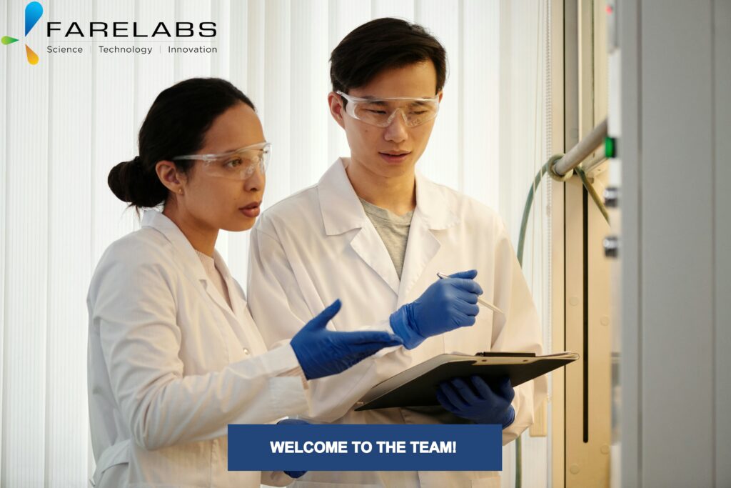 A Female and male scientists in PPE discuss while running an experiment