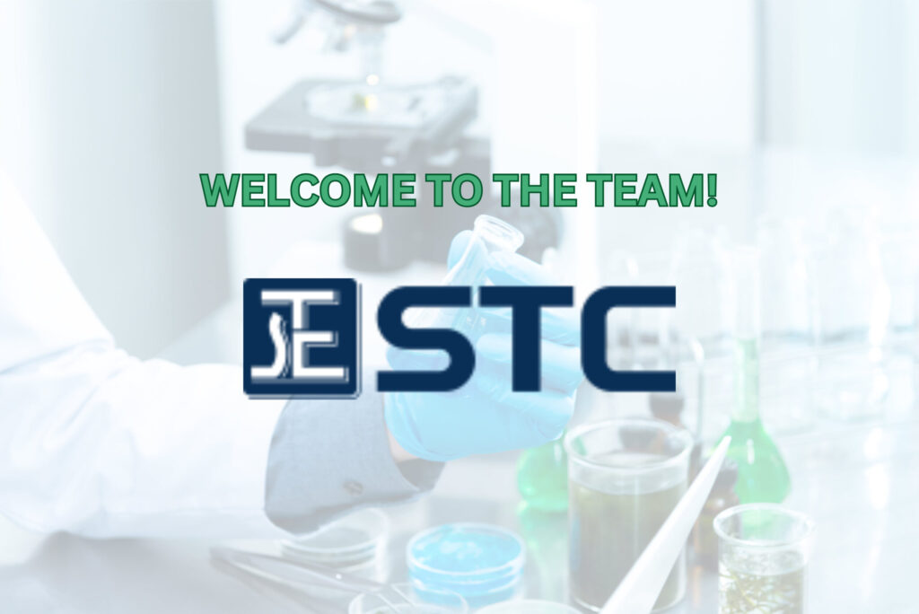 Logo of STC on a visual of a microscope being adjusted by a gloved hand in a lab setting.
