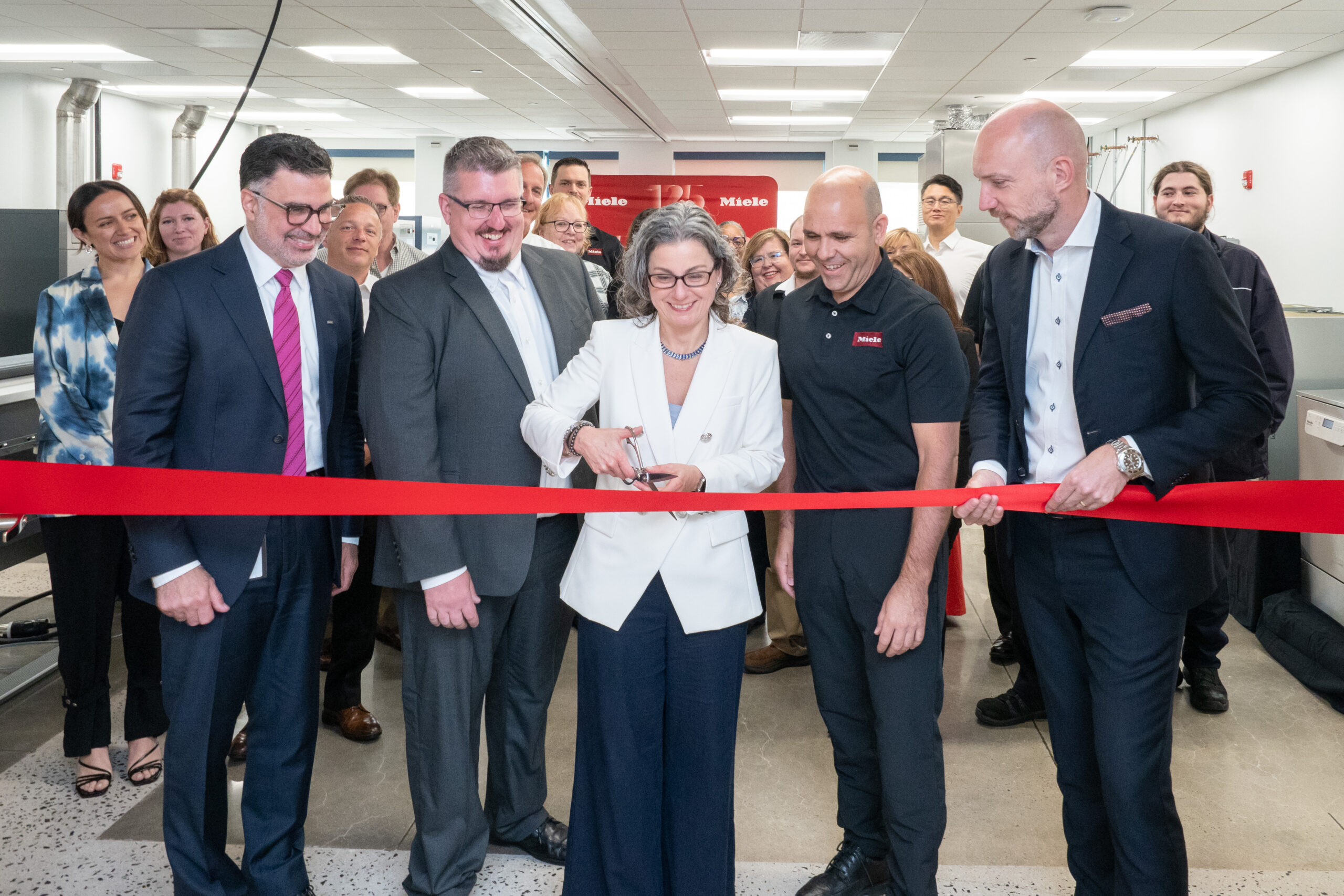Miele executives cutting a ribbon at the opening of a new center
