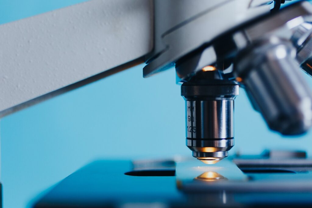 close-up view of microscope showing lens and plate in profile