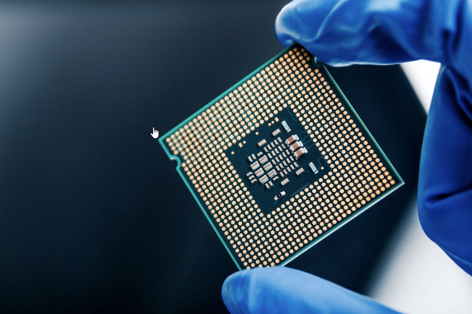 Hand with blue glove holding a large microcircuit