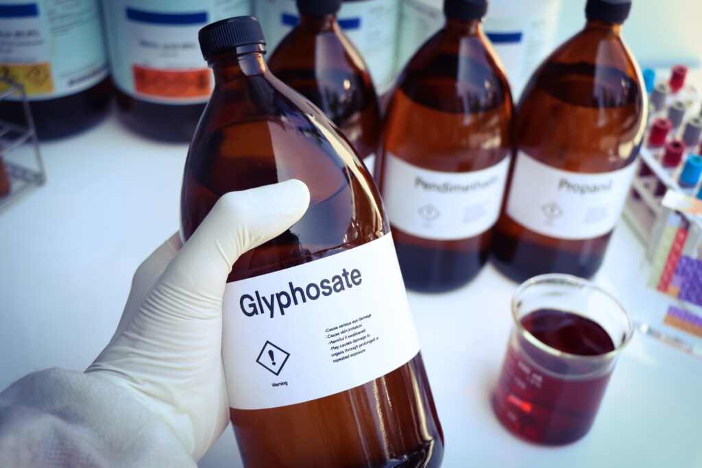 lab tecchnician holding a brown bottle of Glyphosate herbicide
