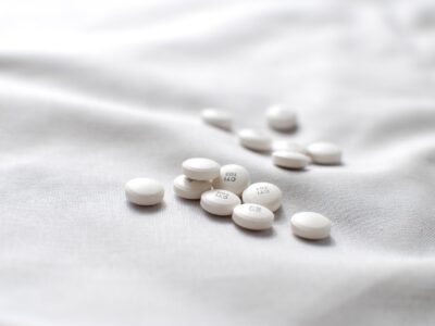 White tablets scattered on a soft, white fabric surface in natural light.