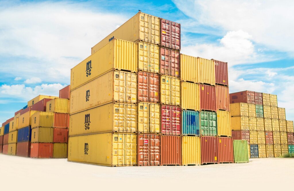 Shipping containers with imported products are stacked at a port or freight facility.